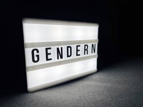 Auf einer Leuchtbox steht das Wort Gendern.